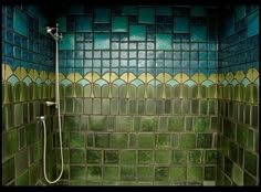 a tiled shower with green and blue tiles