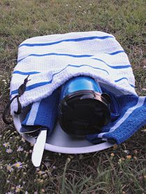 a blue and white striped towel sitting on top of a bowl with a helmet in it