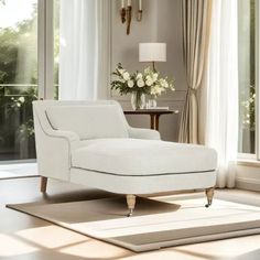 a white chaise lounge chair sitting on top of a rug next to a window