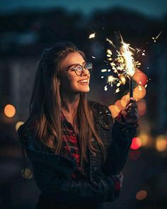 a woman holding a sparkler in her hand