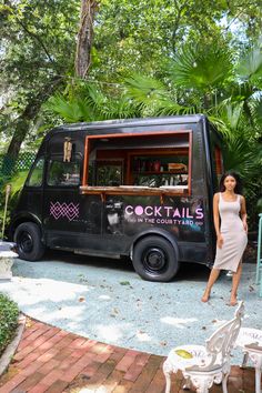 a woman standing in front of a food truck