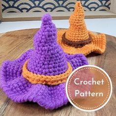 two crocheted witches hats sitting on top of a wooden table next to each other