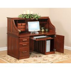 a desk with a computer on it in front of a beige wall and carpeted floor