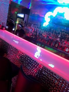 the bar is lit up with colorful lights