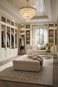 an elegant walk in closet with white furniture and chandelier