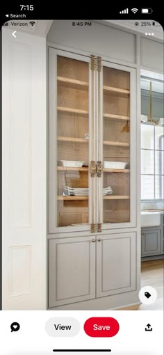 a large white cabinet with glass doors in a kitchen