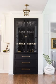 a black china cabinet with wine glasses on it