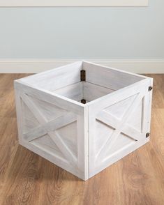 a white wooden box sitting on top of a hard wood floor