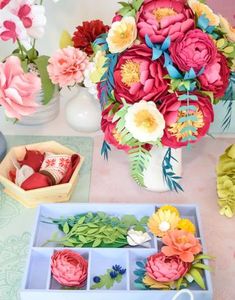 a vase filled with flowers sitting on top of a table next to two boxes of candy