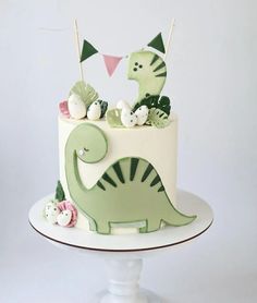 a dinosaur cake with green and white decorations