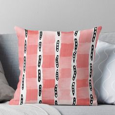 a pink and black pillow on a couch