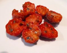 several pieces of tomato sitting on top of a white plate