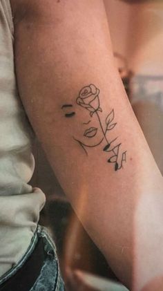 a woman with a rose tattoo on her arm