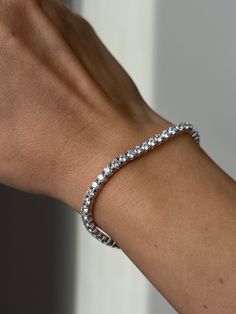 Bask in the luminous brilliance of this exquisite Tennis Bracelet. Crafted with 925 Sterling Silver, this timeless piece is set with 6.00TCW of round-cut created diamonds, delivering a sparkle that is sure to turn heads. Ensuring maximum comfort and security, its 3mm band is exquisitely designed for an effortless fit. This exquisite bracelet finished in high polished rhodium that gives it a stunning shiny look that lasts for many years. Our created diamonds and gemstones are synthetic simulants Dazzling White Sterling Silver Tennis Bracelet, Adjustable Brilliant Cut Tennis Bracelet, Classic Silver Tennis Bracelet With Prong Setting, Adjustable Tennis Bracelet With Brilliant Cut, Adjustable Brilliant Cut Round Tennis Bracelet, Dazzling Round Sterling Silver Diamond Bracelet, Dazzling Sterling Silver Diamond Cut Bracelet, Adjustable Sterling Silver Tennis Bracelet With Brilliant Cut, Classic White Sterling Silver Bracelet With Diamond Accents