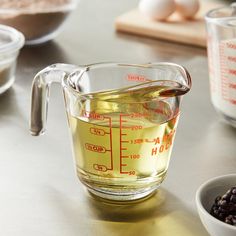 a measuring cup filled with liquid next to other ingredients