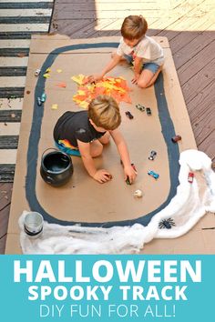 two children are playing with halloween spooky tracks on the ground, and one child is