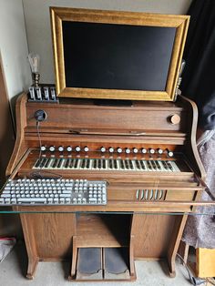 an old pipe organ with keyboard and monitor