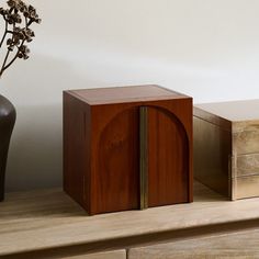 two wooden boxes sitting on top of a table next to a vase with flowers in it