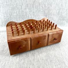 a wooden toy with drawers and pegs in it