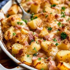 a casserole dish filled with potatoes and ham, garnished with parsley