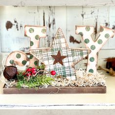 a wooden sign that says joy with a star on top and some decorations around it