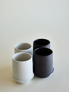 three black and white cups sitting next to each other