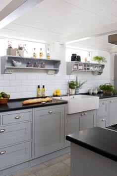 a kitchen with gray cabinets and black counter tops