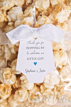 a bag full of popcorn with a baby's shirt tag on the front, and thank you for popping by to welcome our little guy