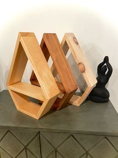 three pieces of wood sitting on top of a green table next to a black statue