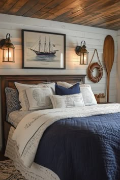 a bed with blue and white comforter next to two wall mounted pictures on the wall