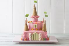 a pink castle cake sitting on top of a white plate