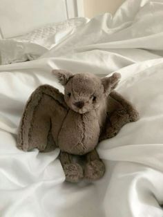 a stuffed animal sitting on top of a white bed