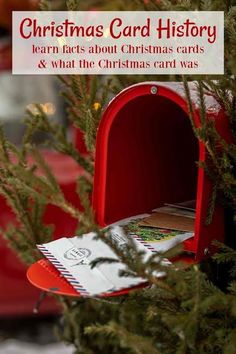 a red mailbox sitting next to a tree with the words christmas card history written on it