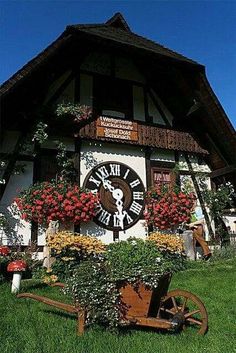 a clock on the side of a building with flowers growing out of it