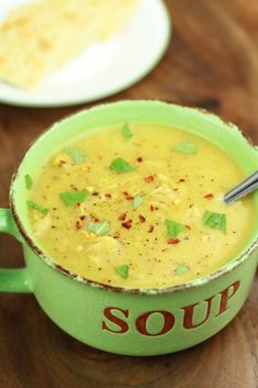 a green bowl filled with soup on top of a wooden table