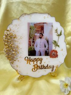 a happy birthday photo frame with a man in white and gold on the front, surrounded by flowers