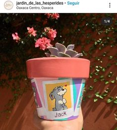 someone is holding up a cup with a plant in it and the name jack on it