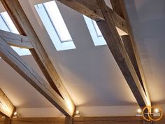 a room with wooden beams and lights on the ceiling is lit up by two lamps