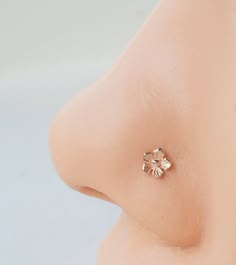 a close up view of the side of a woman's nose with a small flower on it