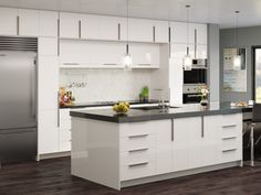 a modern kitchen with white cabinets and stainless steel appliances, along with an island in the middle