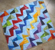 a colorful quilt is laying on the floor