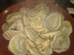 some dumplings are cooking in a brown bowl