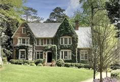 a large house with ivy growing on it's walls and windows in the front yard