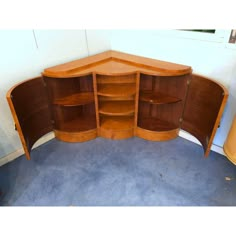 a curved wooden shelf with shelves in the corner