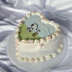 a white cake with an image of a sheep on it's side, sitting on a plate