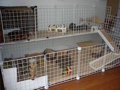 several cages are stacked on top of each other in front of a wall and floor