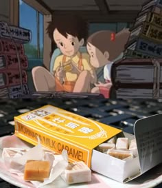 there is a box of milk caramels on the plate next to an anime scene