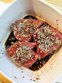 some meat with sauce and sesame seeds in a white dish