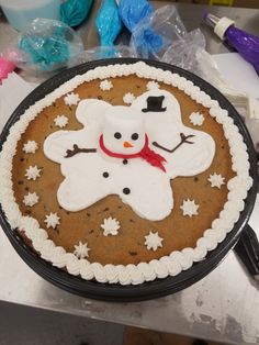 a cake decorated like a snowman on top of a table