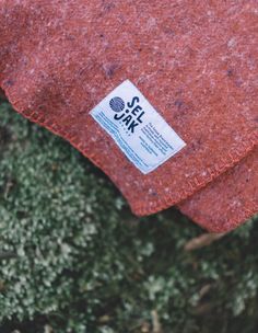 a close up of a red cloth with a sticker on the end of it